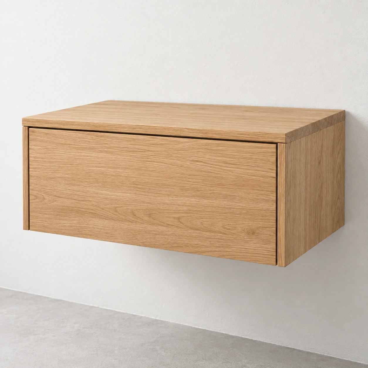 A modern wall-mounted floating cabinet with a light oak wood grain finish, shown against a neutral off-white wall and gray floor.