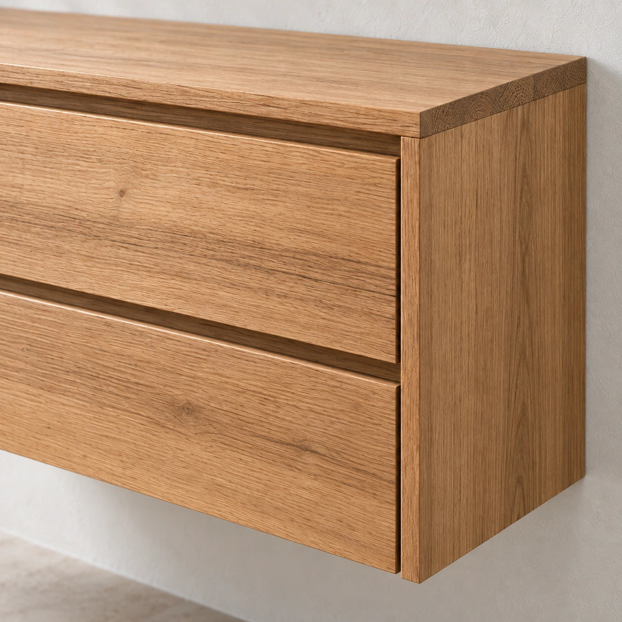 Close-up of a wall-mounted wooden dresser with two drawers, showing a warm oak wood grain finish against a light neutral wall.