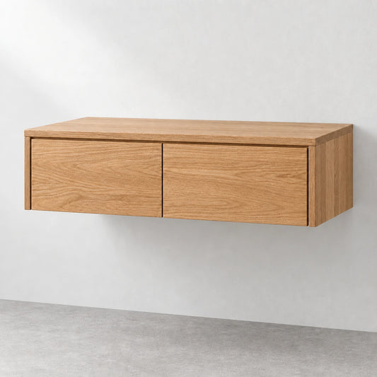 A modern floating wall cabinet with a light oak wood finish, featuring two large drawers and a minimalist design, mounted on a light gray wall above a concrete floor.